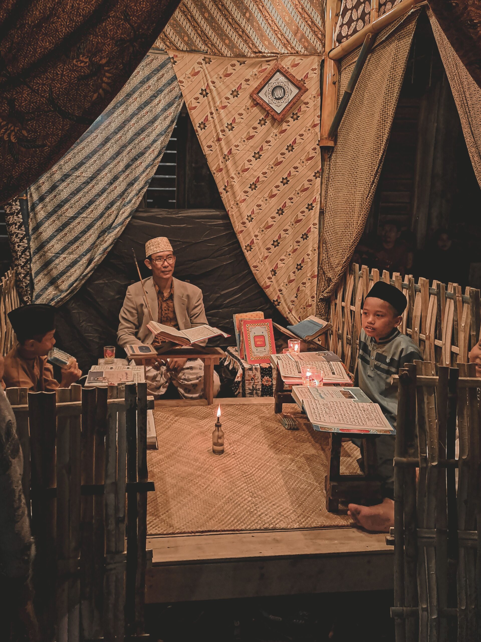 A traditional classroom setting with children studying under candlelight in a rustic environment.